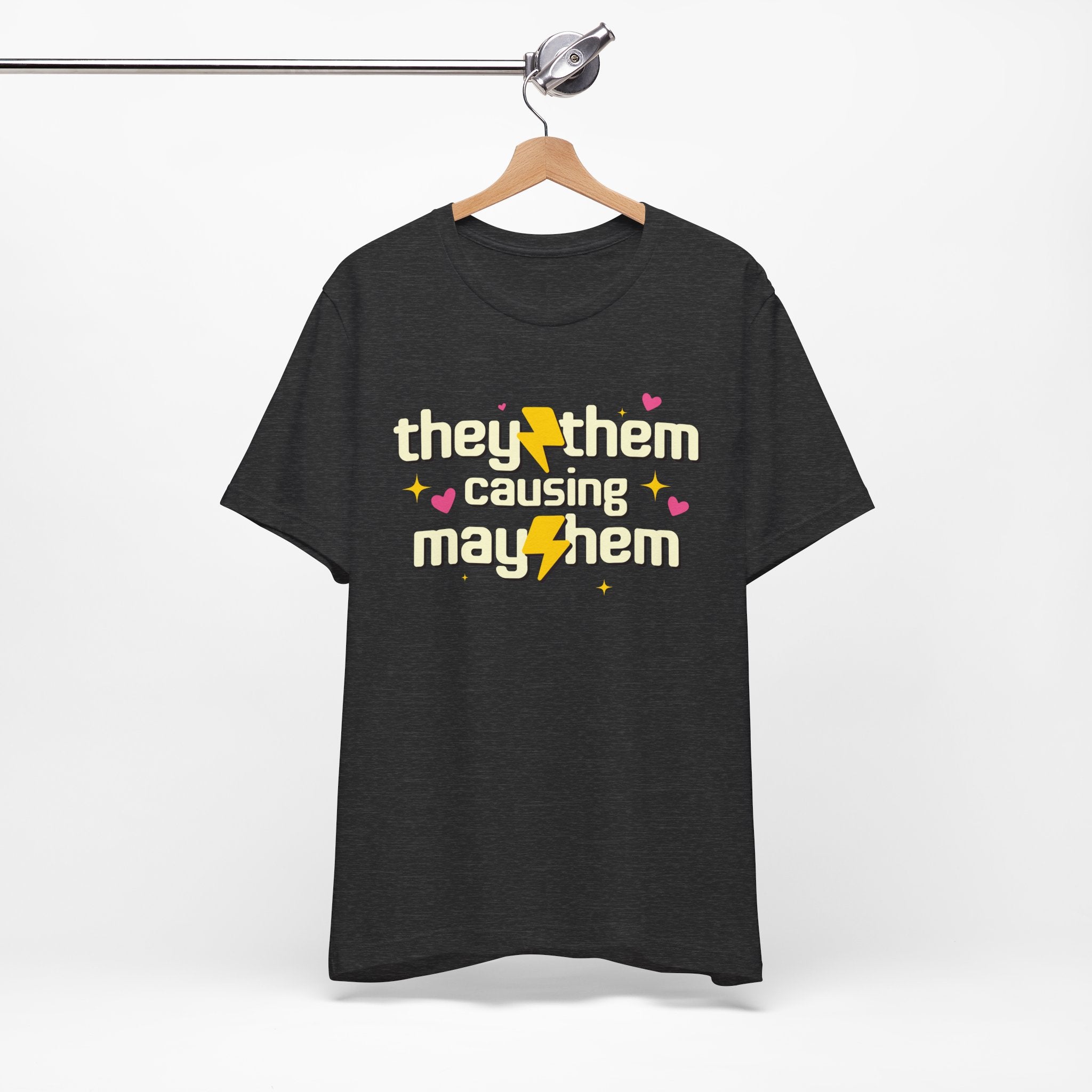 Black t-shirt with 'they/them causing mayhem' text on a hanger against a white background