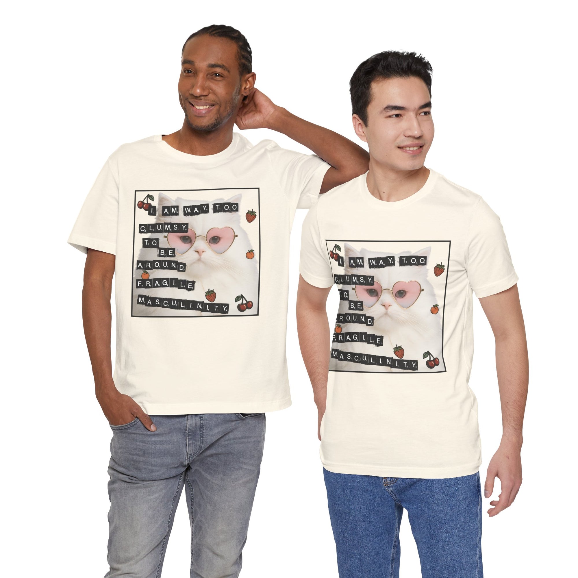 Two men wearing cream t-shirt featuring a fluffy white cat in pink heart-shaped sunglasses with ransom-note style text that says “I am way too clumsy to be around fragile masculinity.”