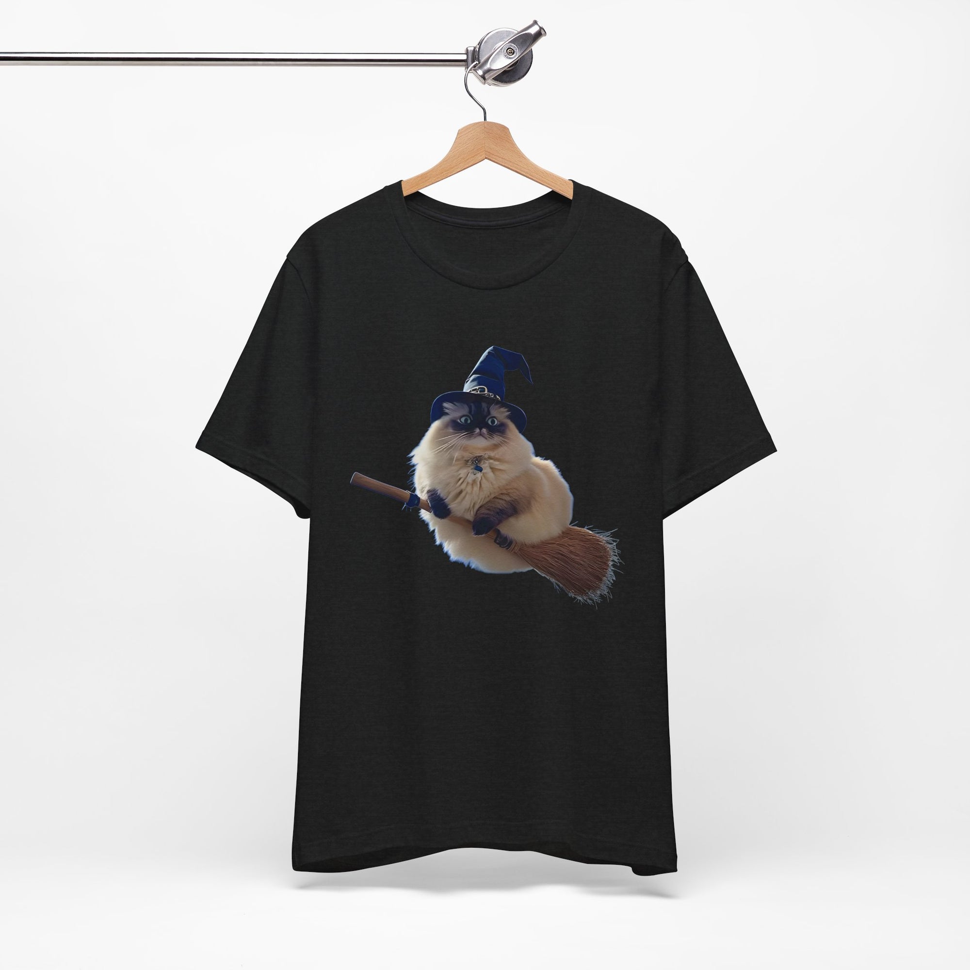 Black t-shirt with a graphic of a cat in a witch hat and broom on a hanger against a white background