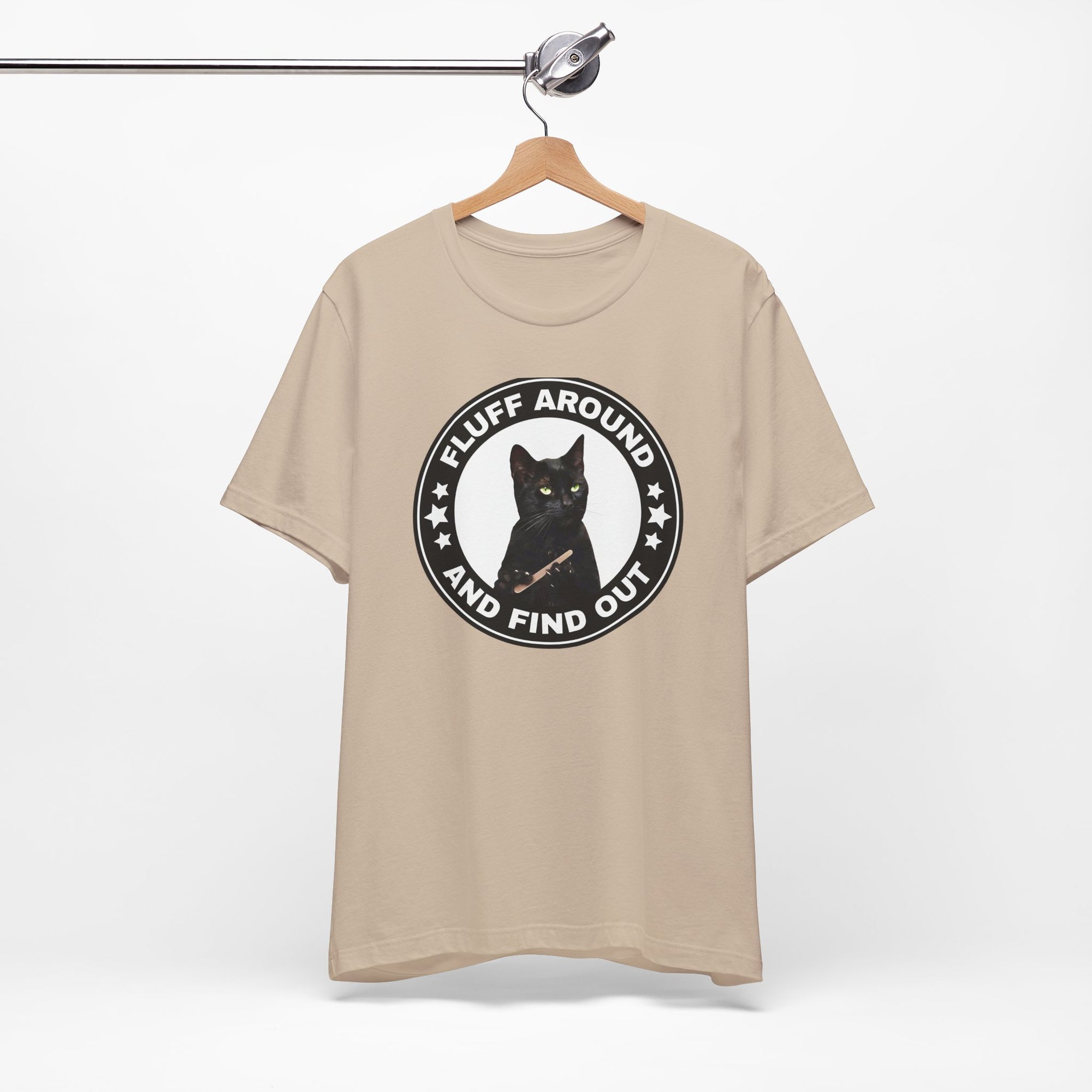t-shirt featuring a circular badge design with a black cat and the phrase “Fluff Around and Find Out.”
