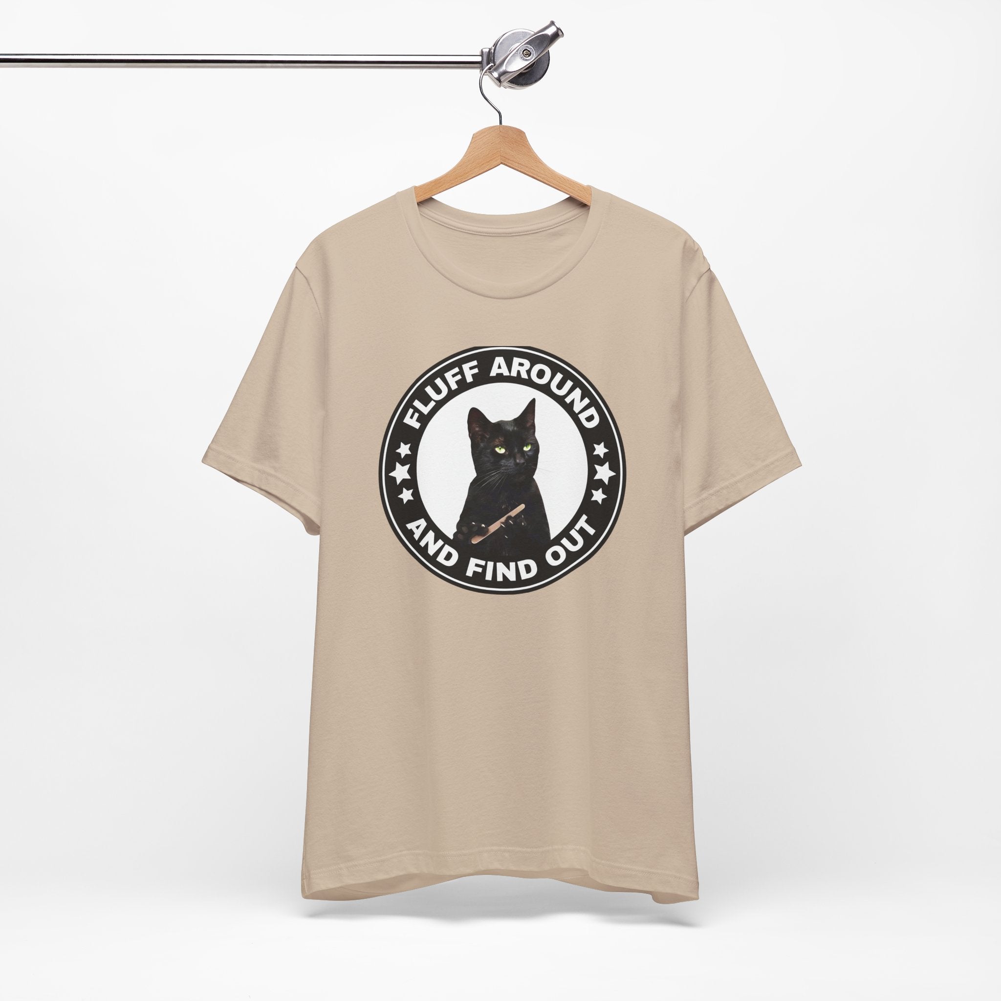 t-shirt featuring a circular badge design with a black cat and the phrase “Fluff Around and Find Out.”
