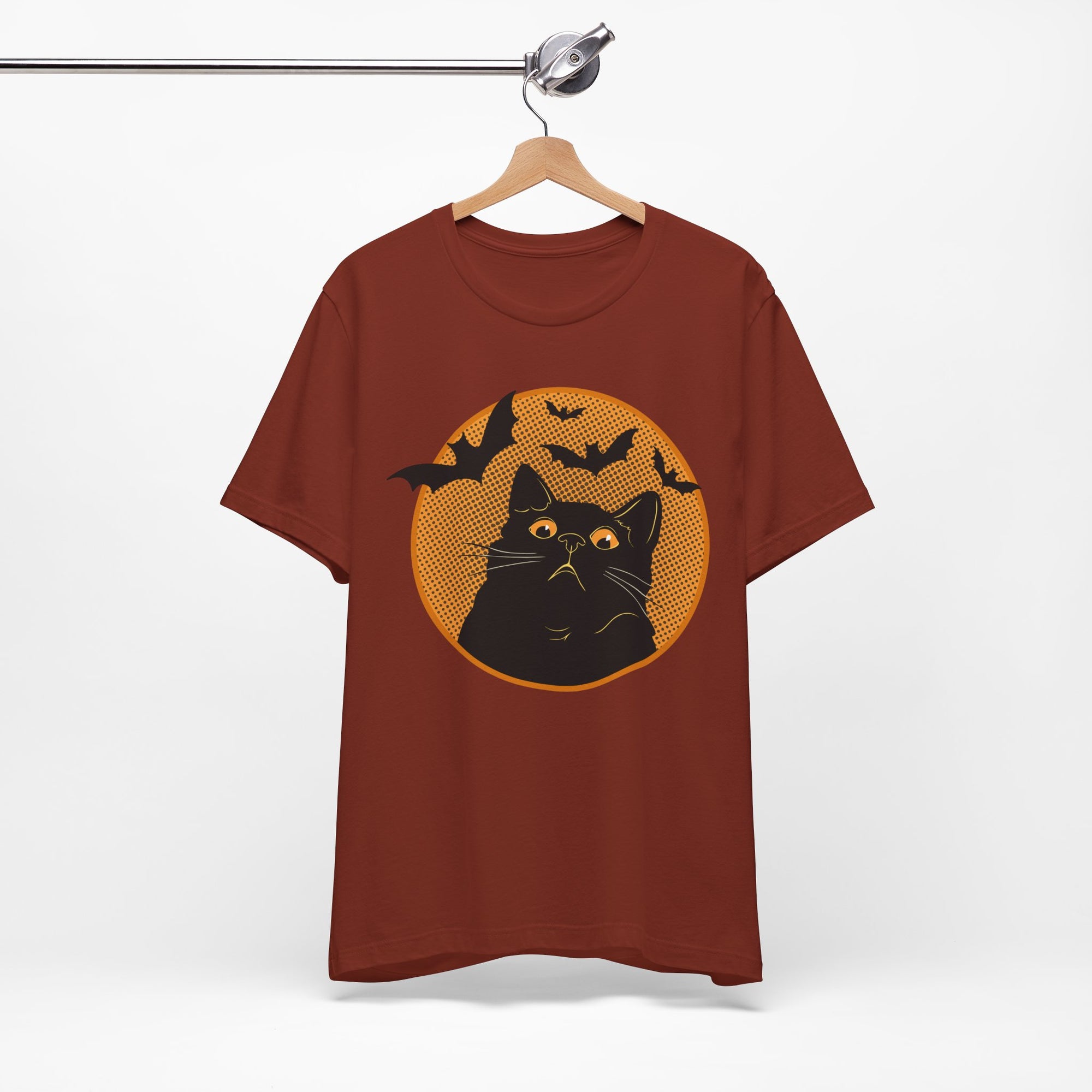 Red t-shirt featuring a retro-style black cat graphic with orange moon, flying bats, and Halloween-inspired details.