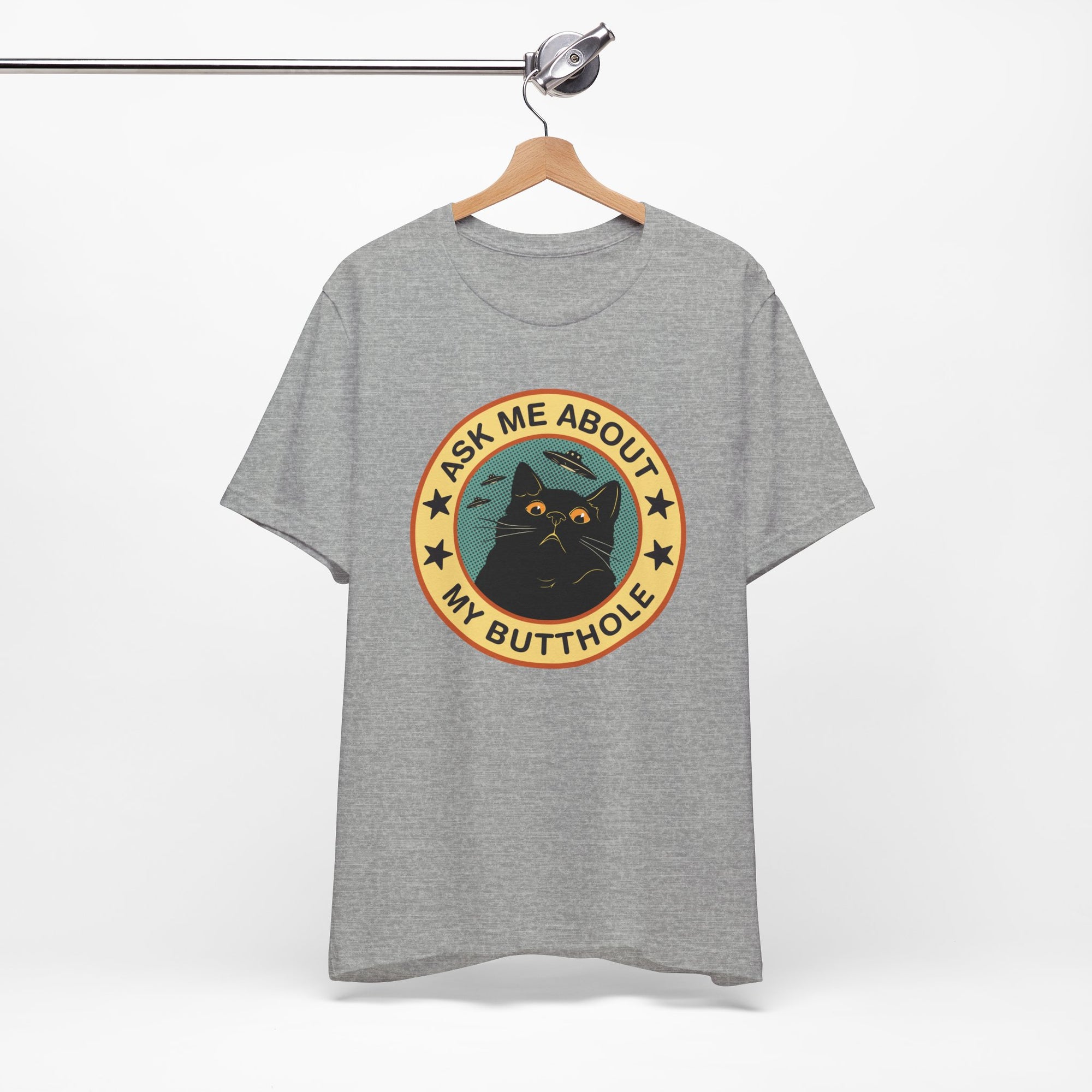 Gray t-shirt with a graphic design featuring a cat and text on a hanger against a white background