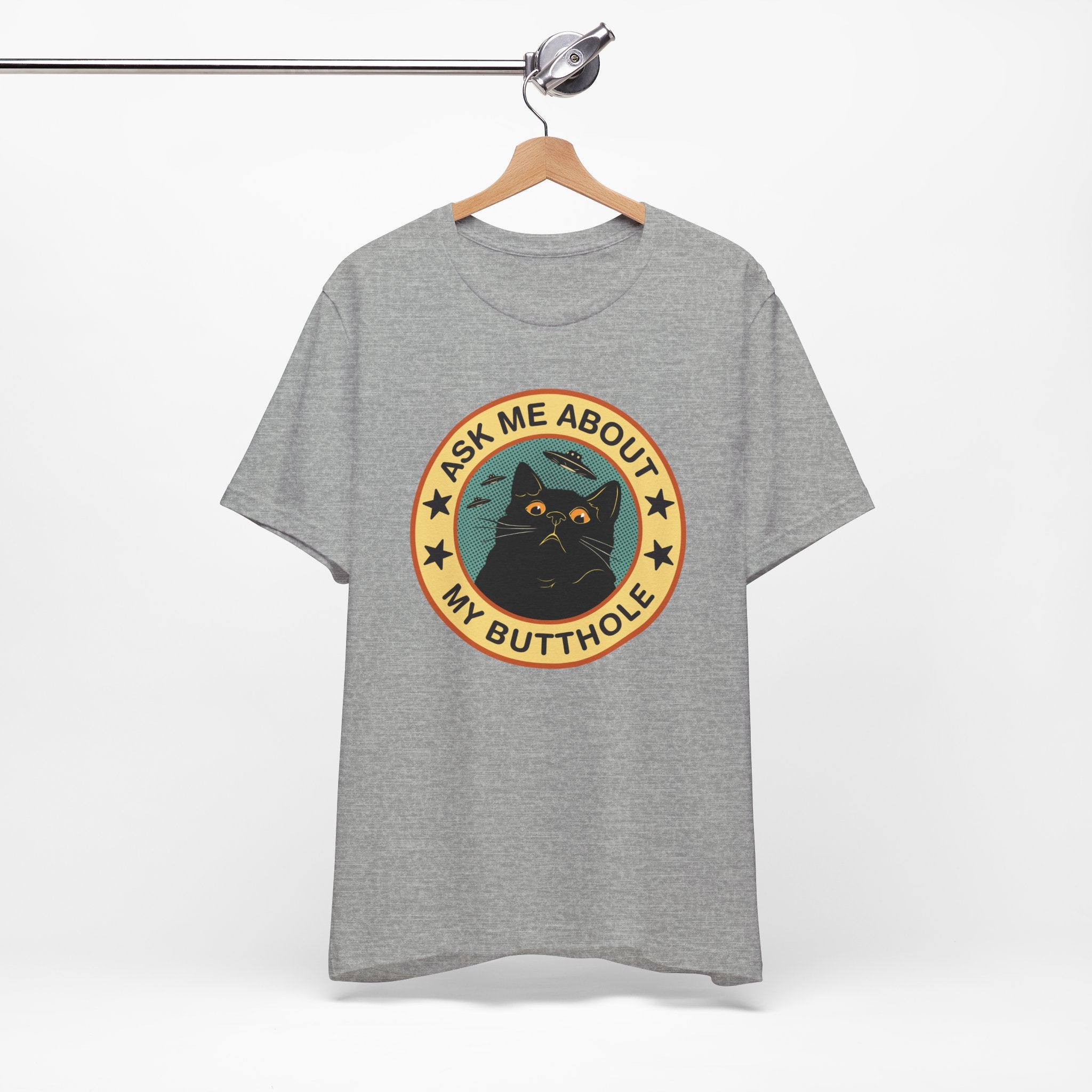 Gray t-shirt with a graphic design featuring a cat and text on a hanger against a white background