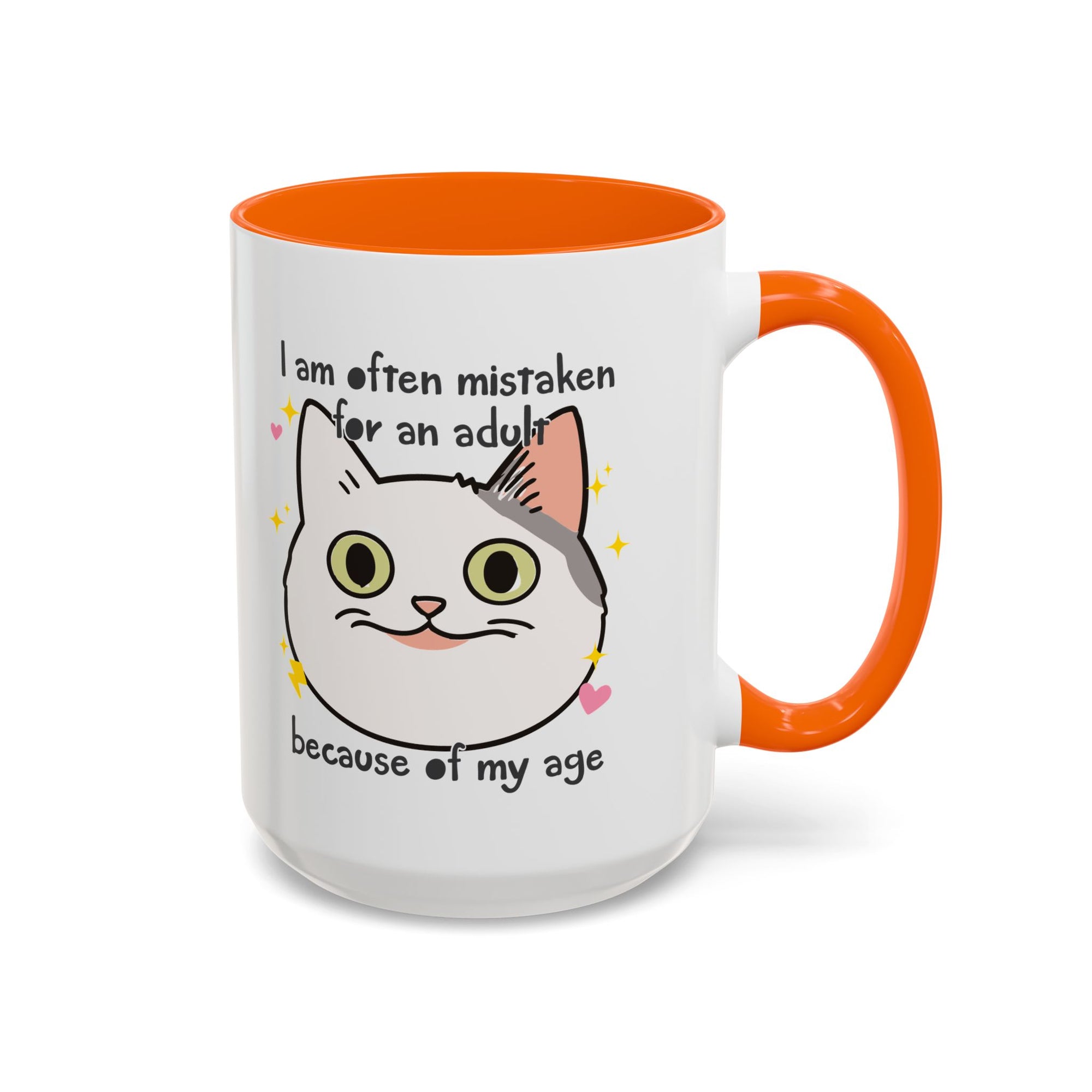 White ceramic mug with orange handle and interior featuring a cute wide-eyed cat face, hearts, sparkles, and the phrase “I am often mistaken for an adult because of my age.”
