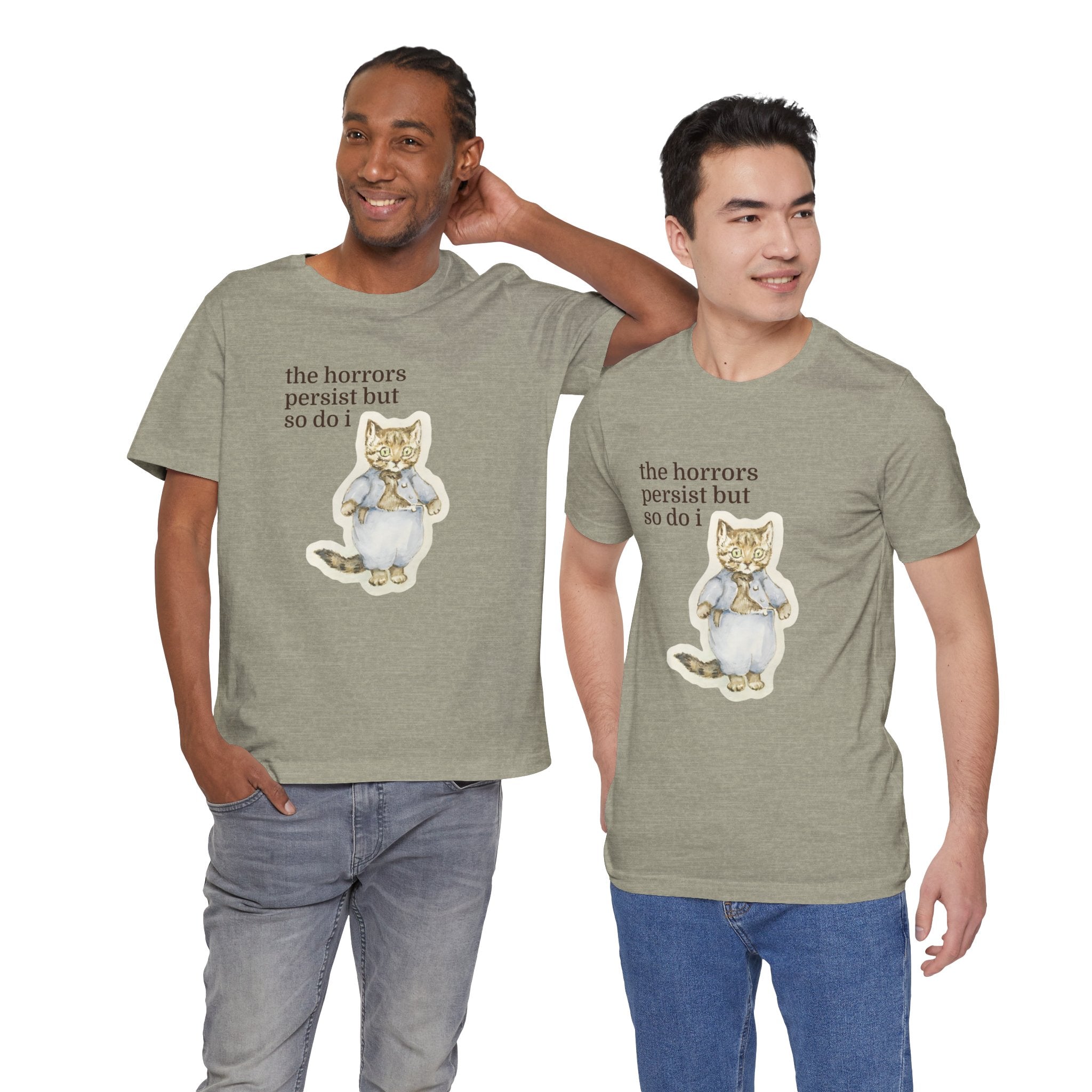 Two men wearing matching green t-shirt featuring a vintage-style illustrated cat in blue clothing with the phrase “the horrors persist but so do i.”