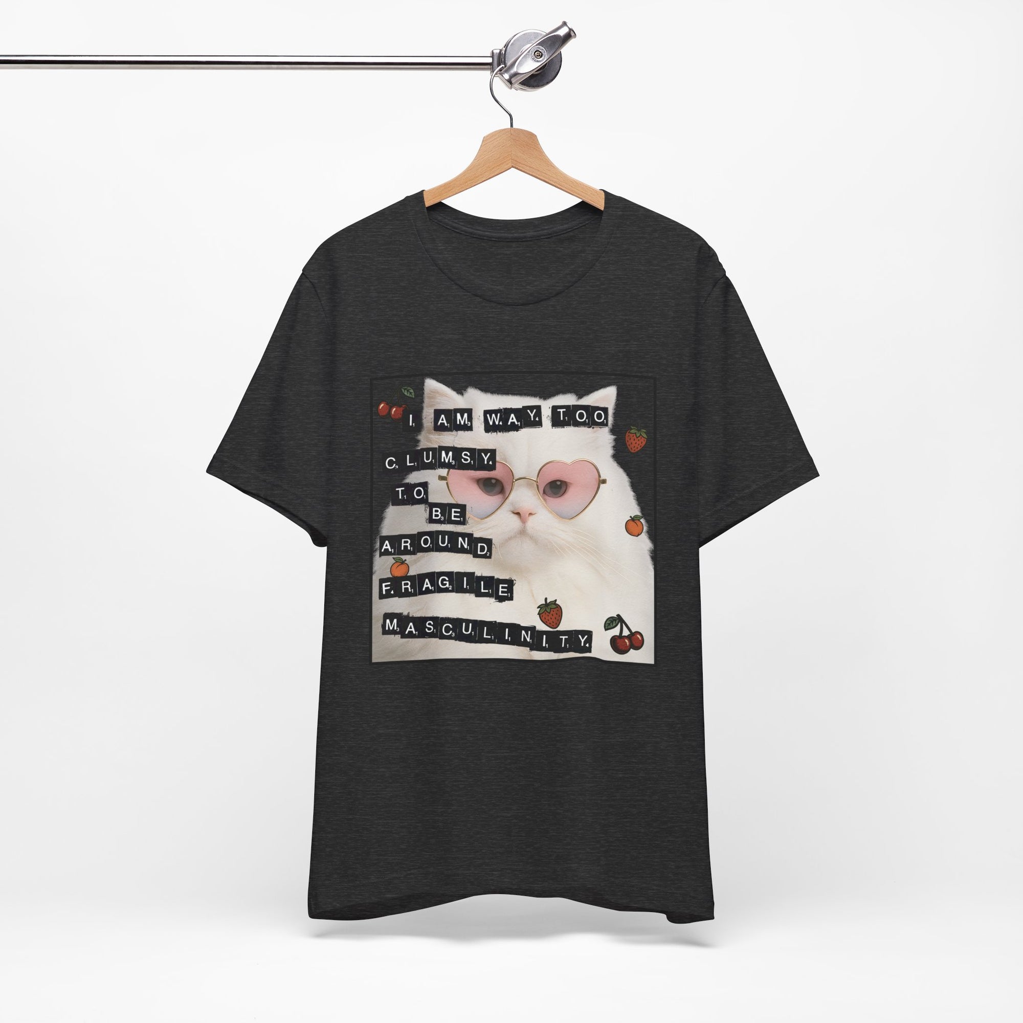Black t-shirt featuring a fluffy white cat in pink heart-shaped sunglasses with ransom-note style text that says “I am way too clumsy to be around fragile masculinity.”