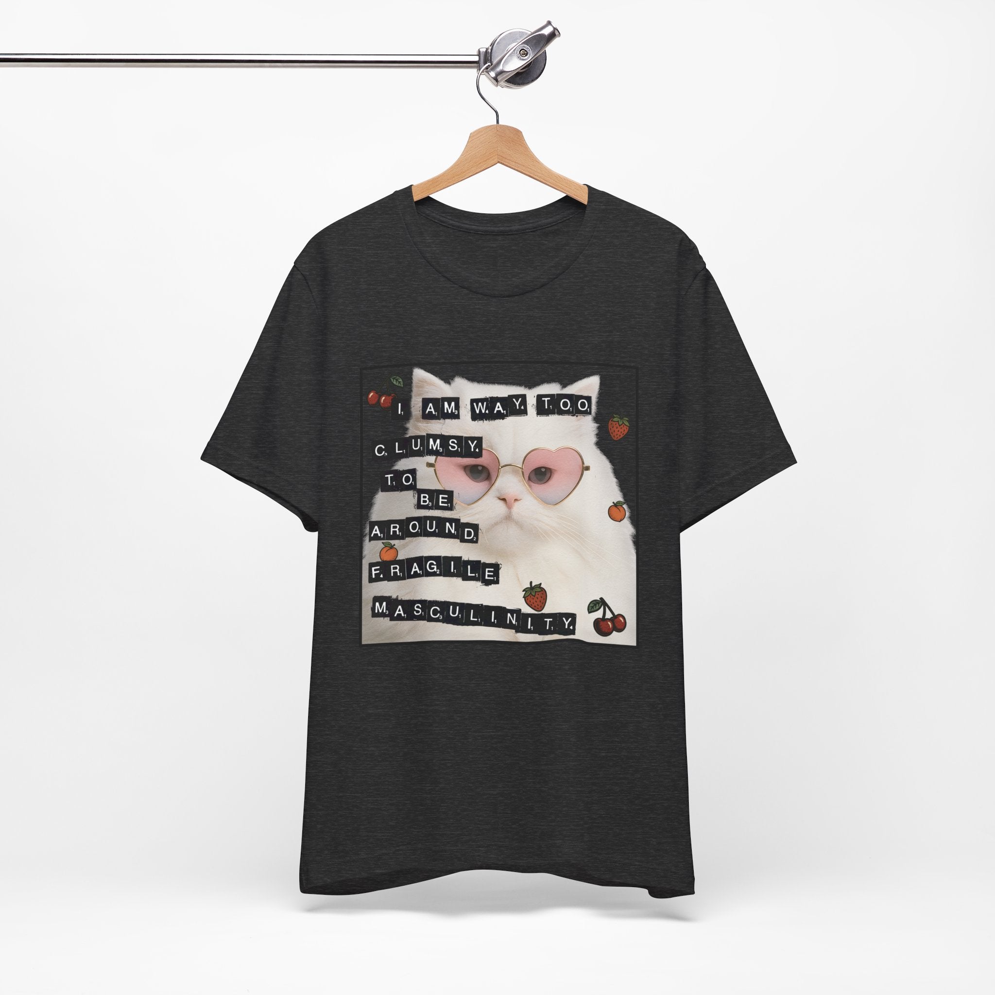 Black t-shirt featuring a fluffy white cat in pink heart-shaped sunglasses with ransom-note style text that says “I am way too clumsy to be around fragile masculinity.”