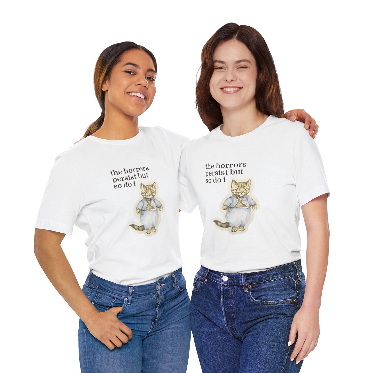 Two women wearing white t-shirt featuring a vintage-style illustrated cat in blue clothing with the phrase “the horrors persist but so do i.”