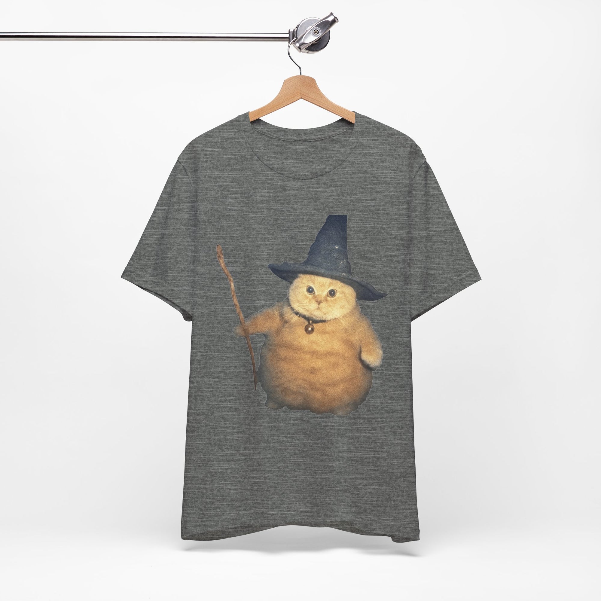 Gray t-shirt with a cat wearing a witch hat and holding a broomstick on a hanger.