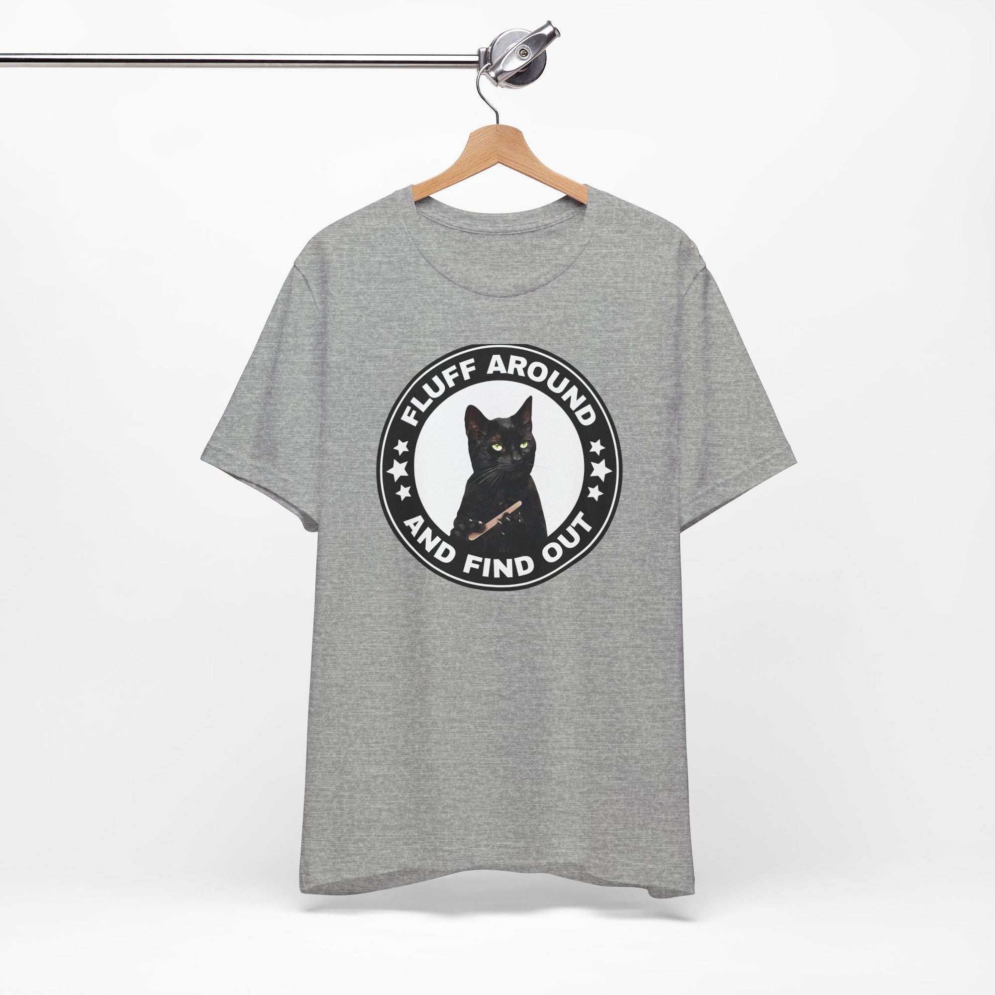 Gray t-shirt featuring a circular badge design with a black cat and the phrase “Fluff Around and Find Out.”
