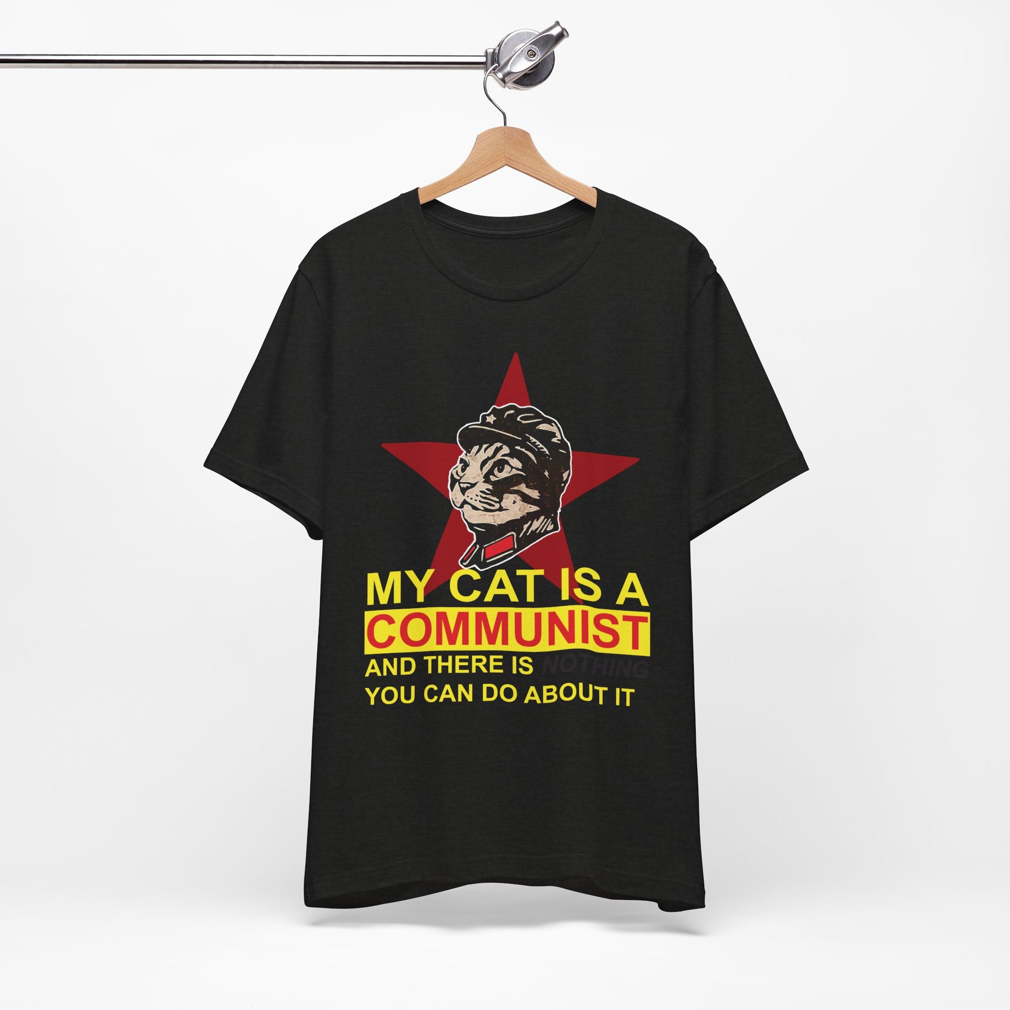 Black t-shirt with a graphic of a cat in a communist uniform and text on a hanger against a white background