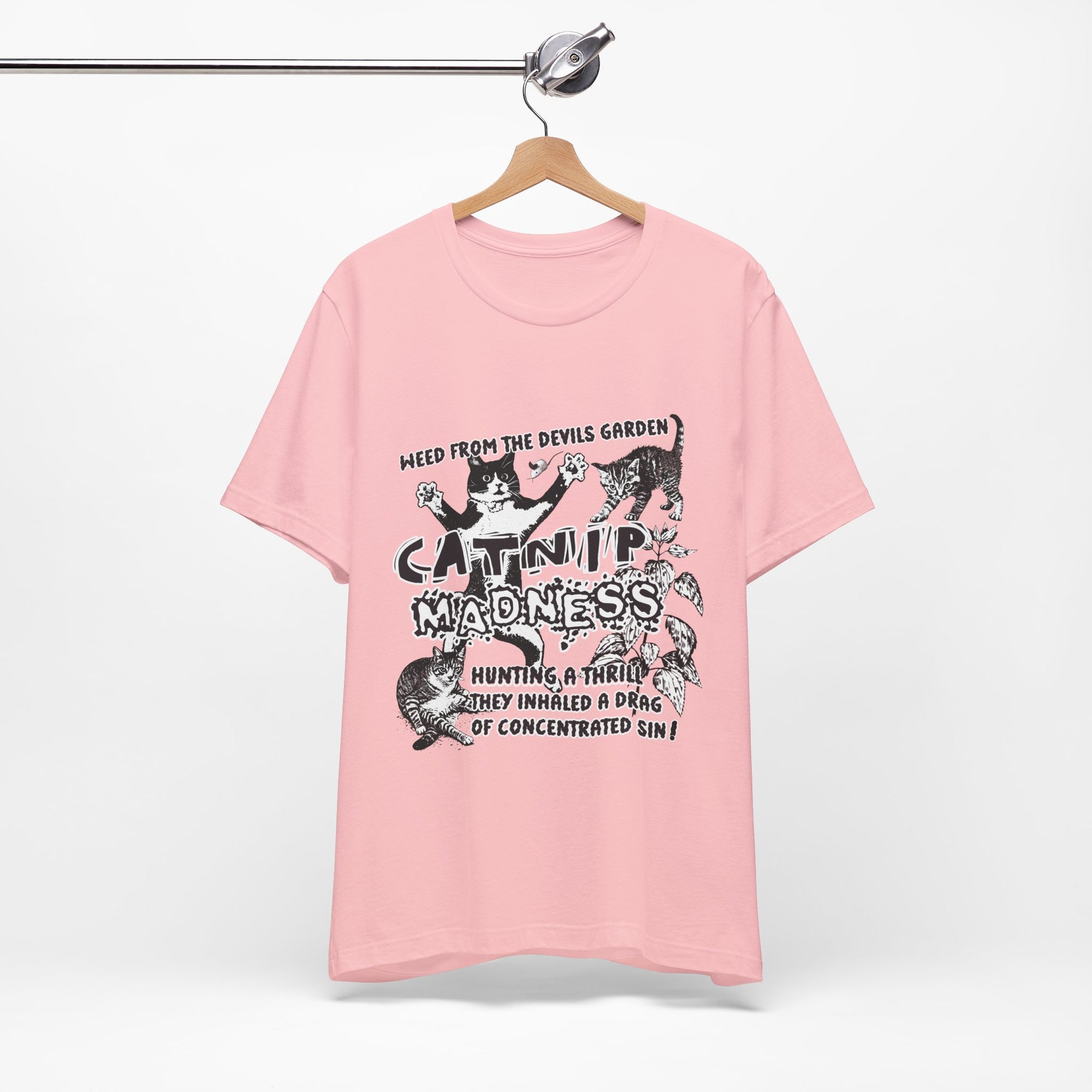Pink t-shirt with graphic design and text on a hanger against a white background