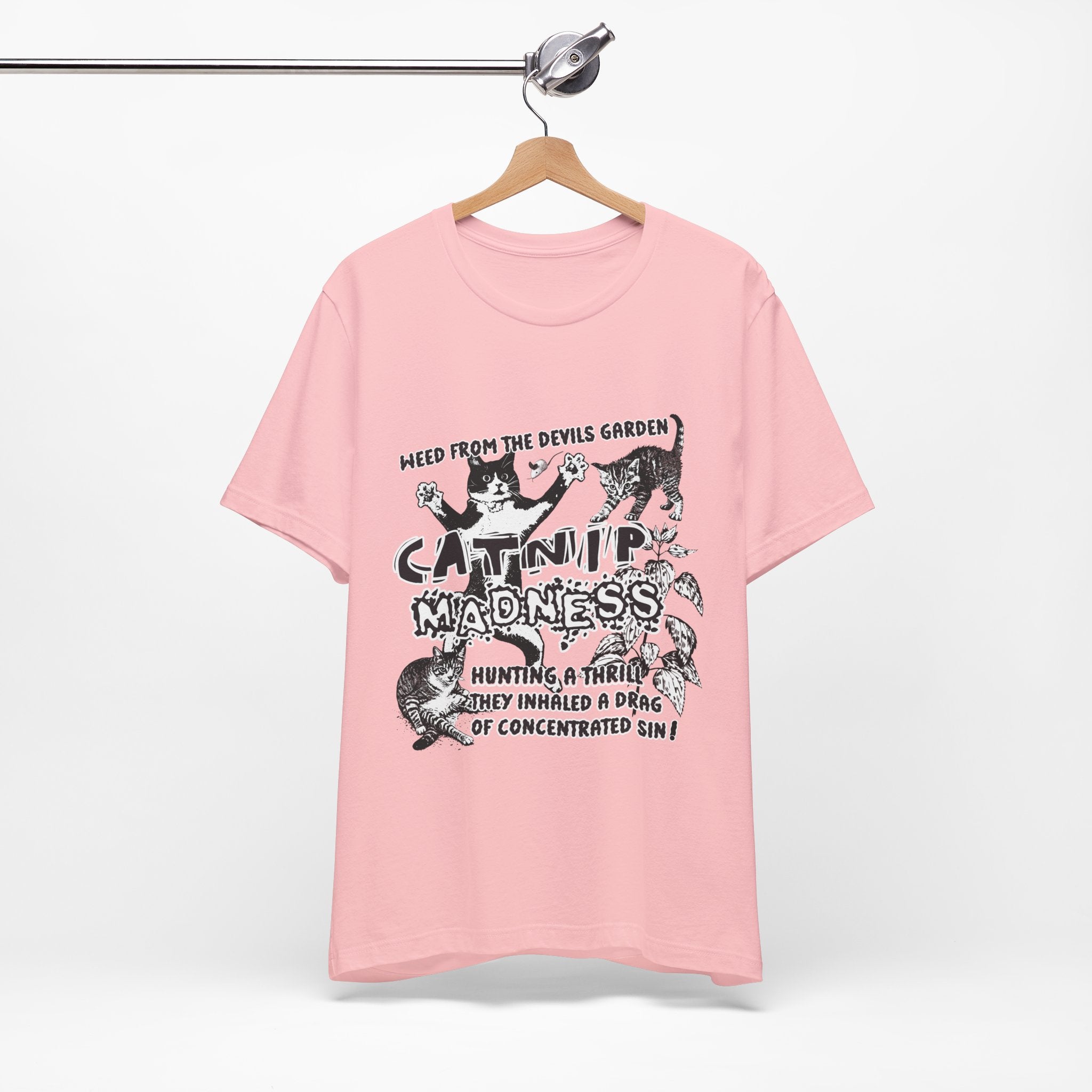 Pink t-shirt with graphic design and text on a hanger against a white background