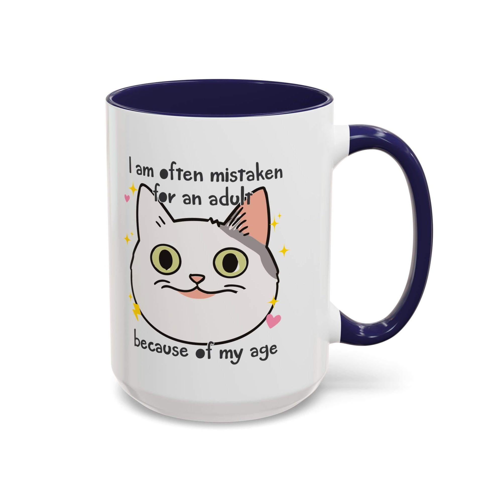 White ceramic mug with blue handle and interior featuring a cute wide-eyed cat face, hearts, sparkles, and the phrase “I am often mistaken for an adult because of my age.”
