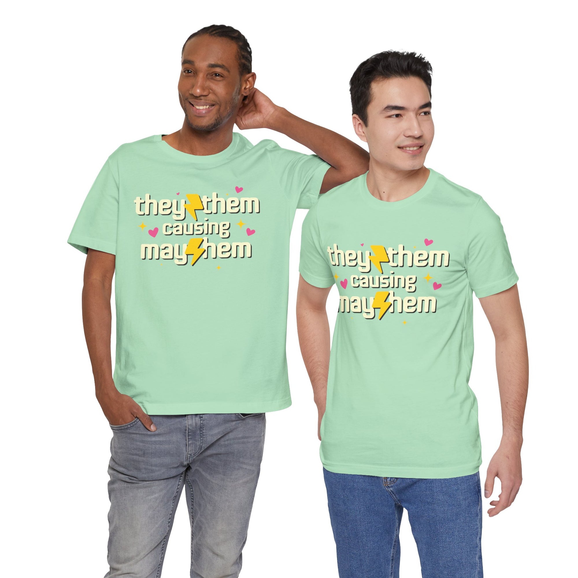 Two men wearing matching light green t-shirts with a pink graphic and text.