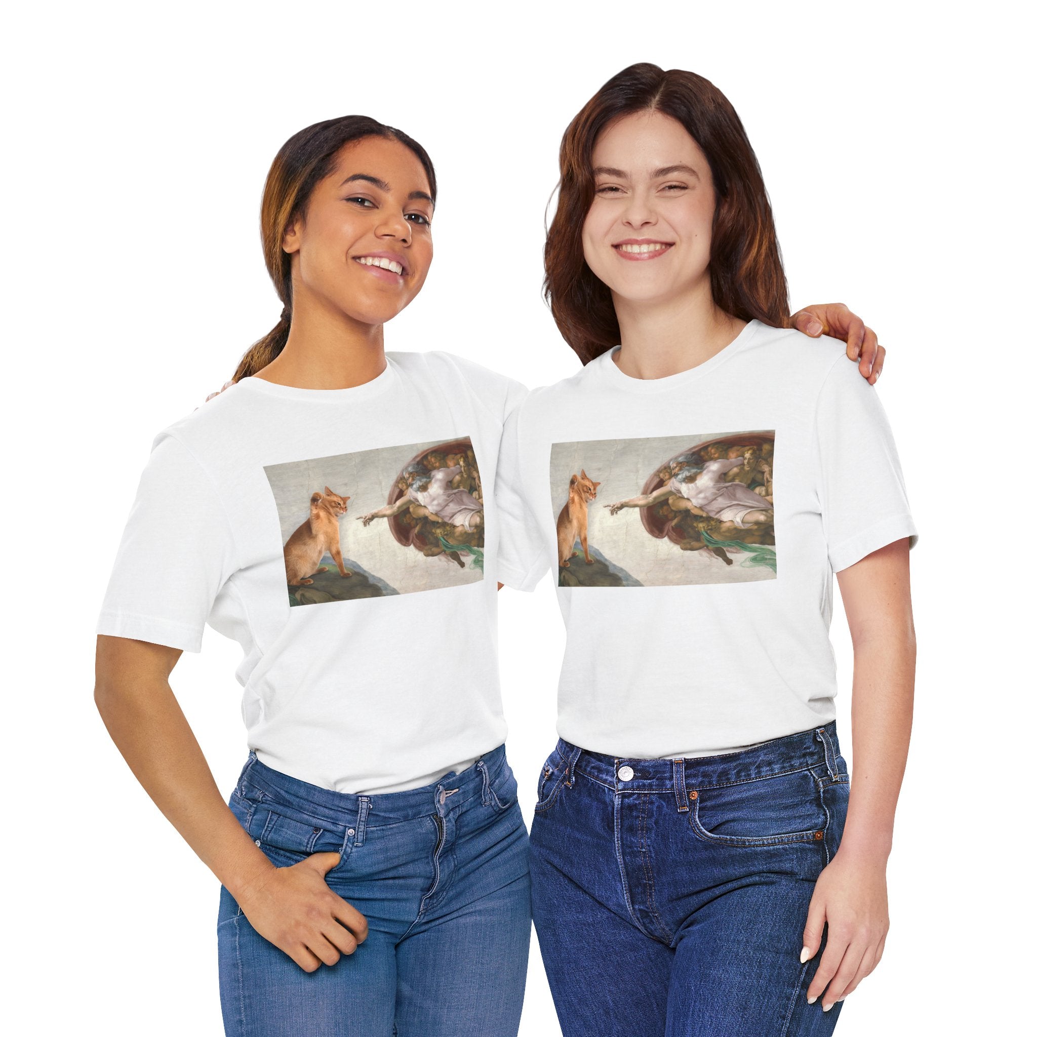 Two women wearing white t-shirts with a graphic design of acat and god on a white background.