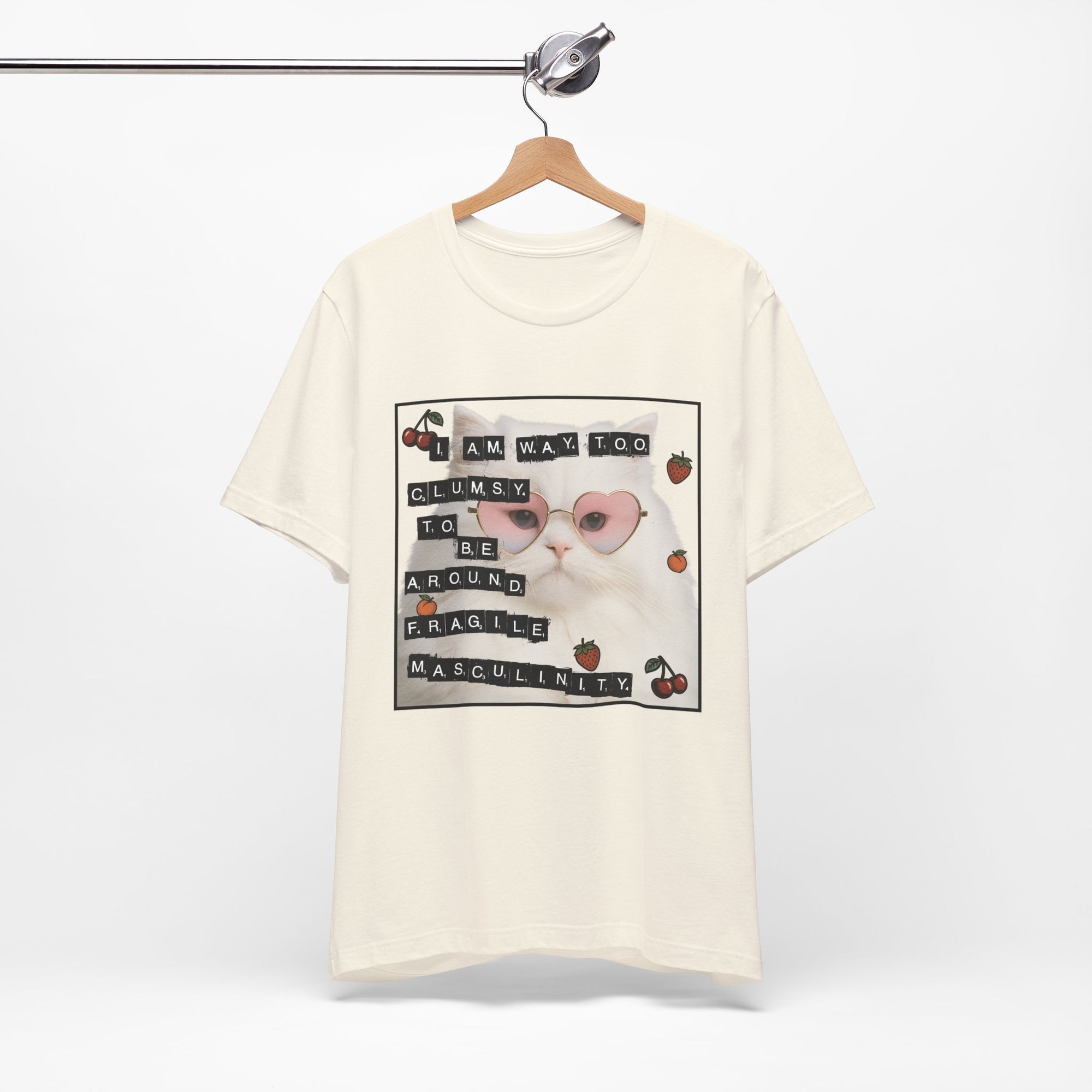 Natural t-shirt featuring a fluffy white cat in pink heart-shaped sunglasses with ransom-note style text that says “I am way too clumsy to be around fragile masculinity.”