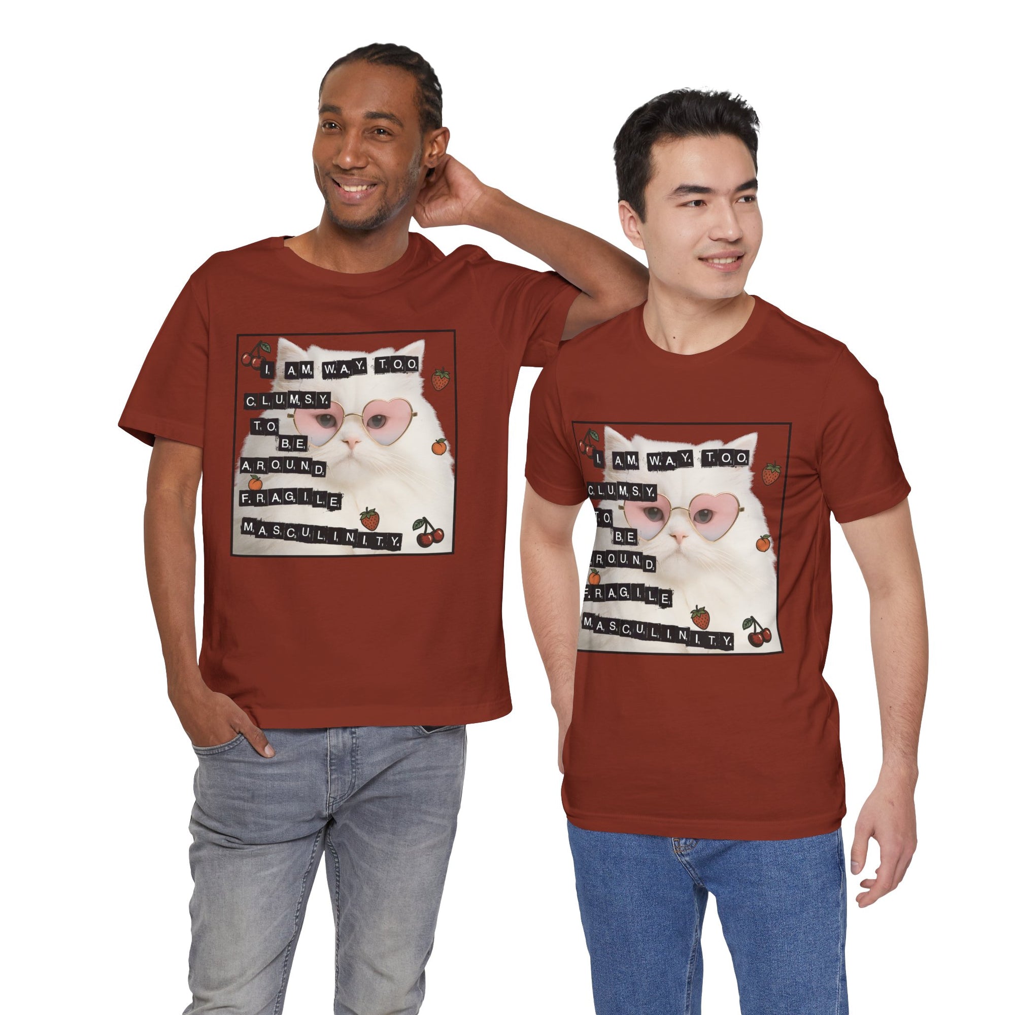 Two men wearing red t-shirt featuring a fluffy white cat in pink heart-shaped sunglasses with ransom-note style text that says “I am way too clumsy to be around fragile masculinity.”