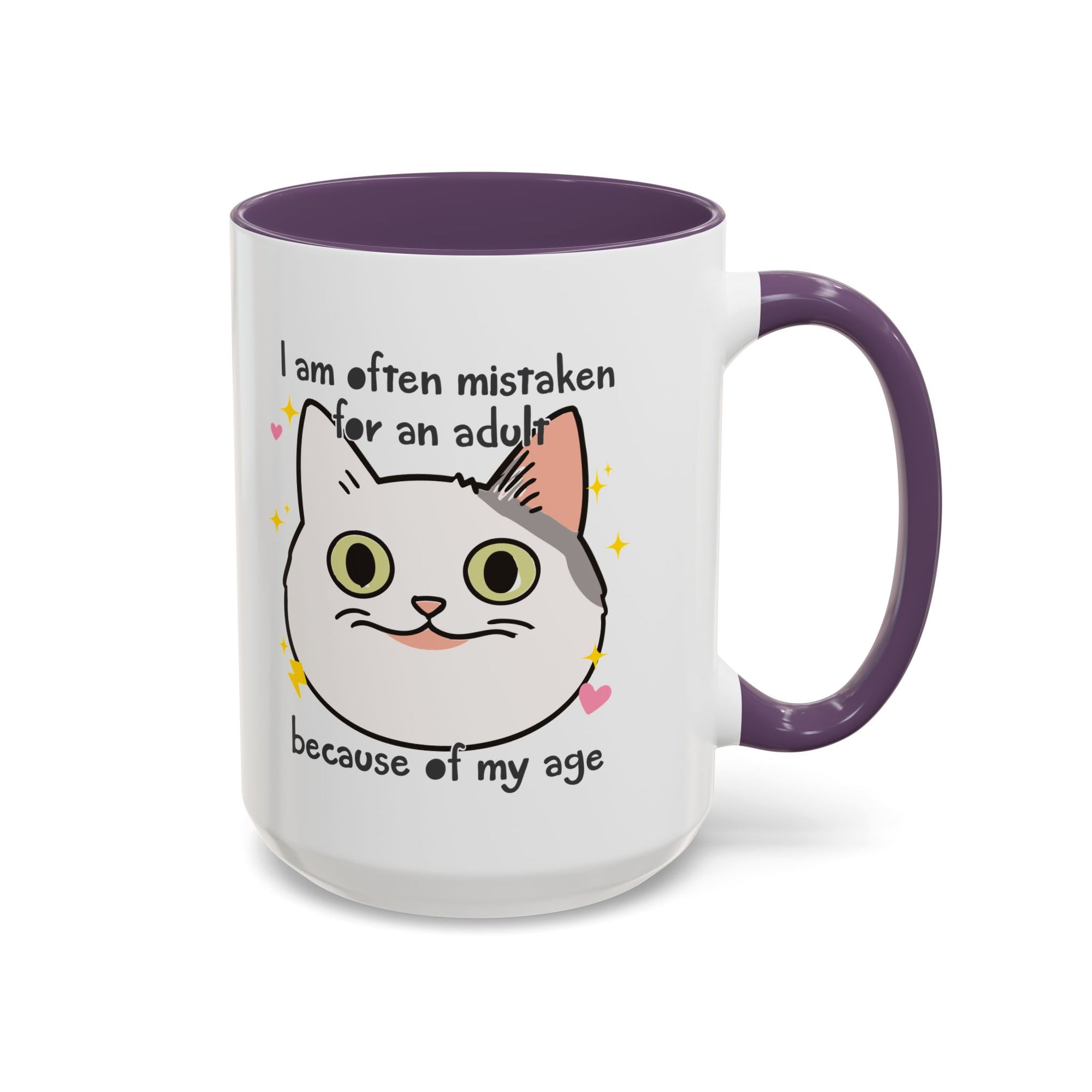 White ceramic mug with purple handle and interior featuring a cute wide-eyed cat face, hearts, sparkles, and the phrase “I am often mistaken for an adult because of my age.”
