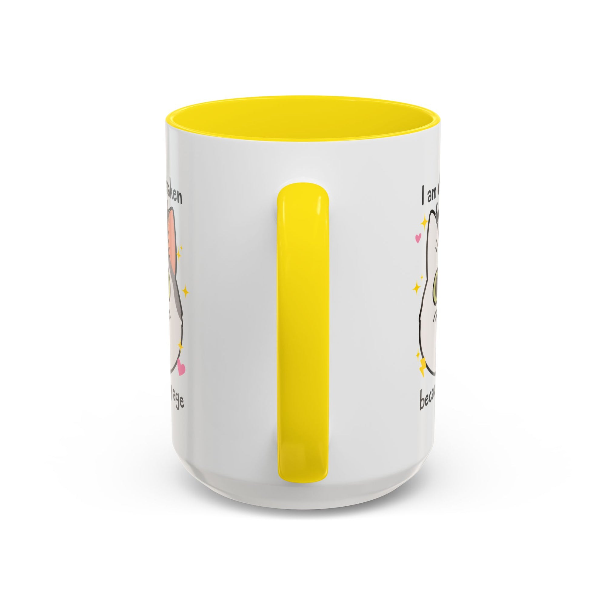 White ceramic mug with yellow handle and interior featuring a cute wide-eyed cat face, hearts, sparkles, and the phrase “I am often mistaken for an adult because of my age.”
