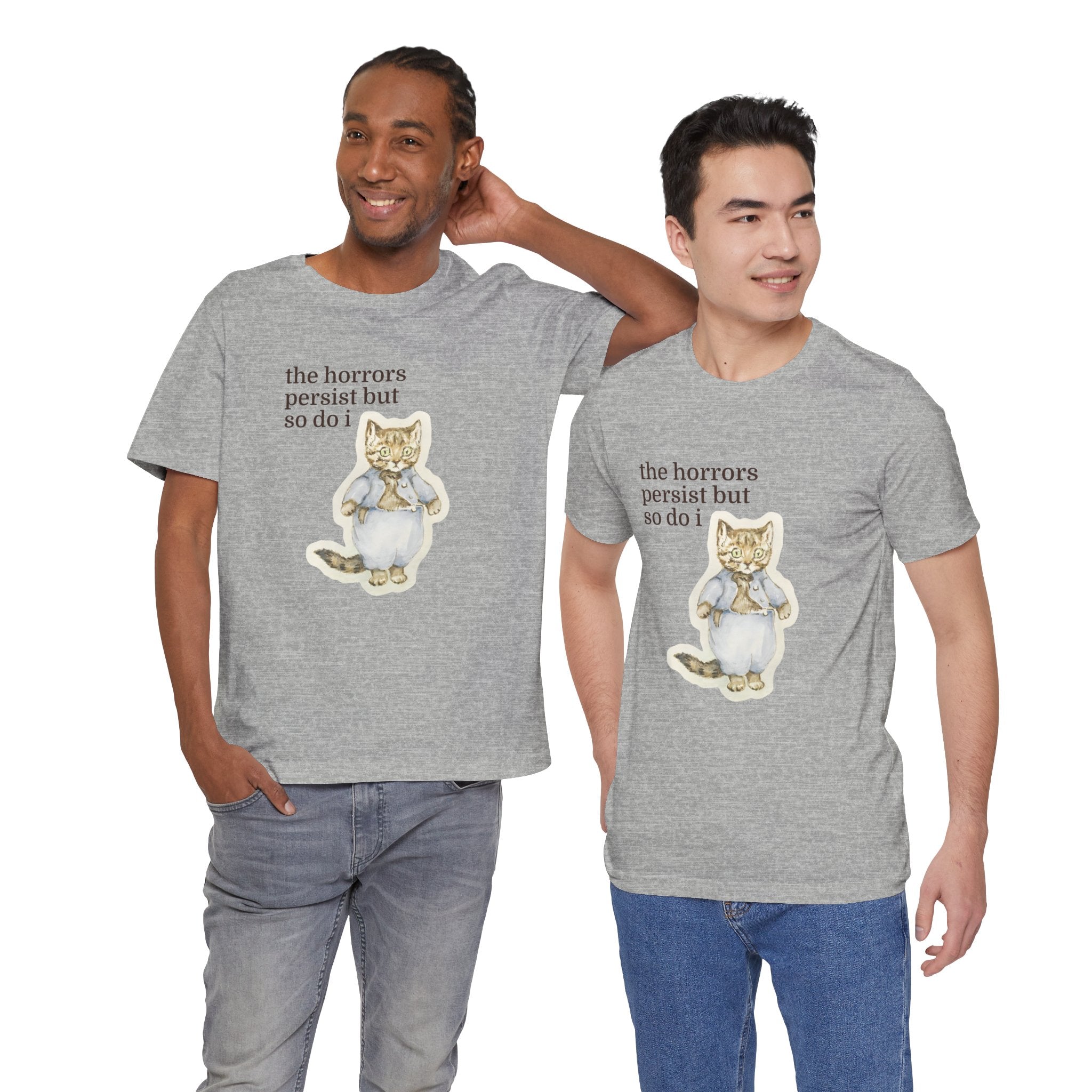 Two men wearing gray t-shirt featuring a vintage-style illustrated cat in blue clothing with the phrase “the horrors persist but so do i.”