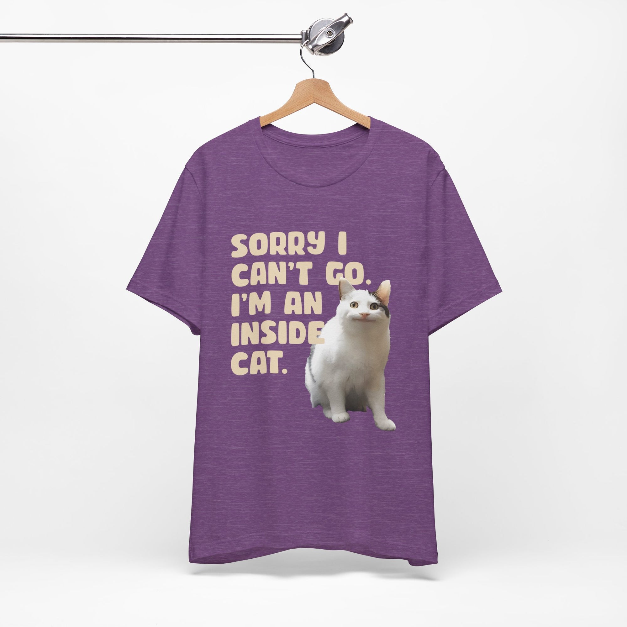 Purple t-shirt with a cat graphic and text on a hanger against a white background