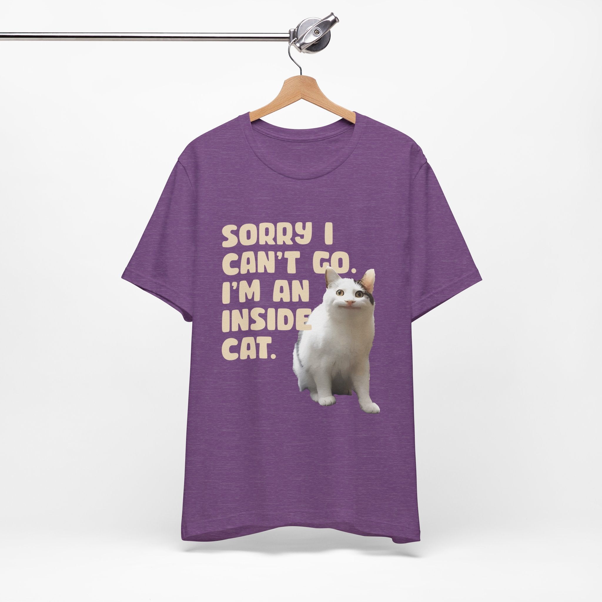 Purple t-shirt with a cat graphic and text on a hanger against a white background