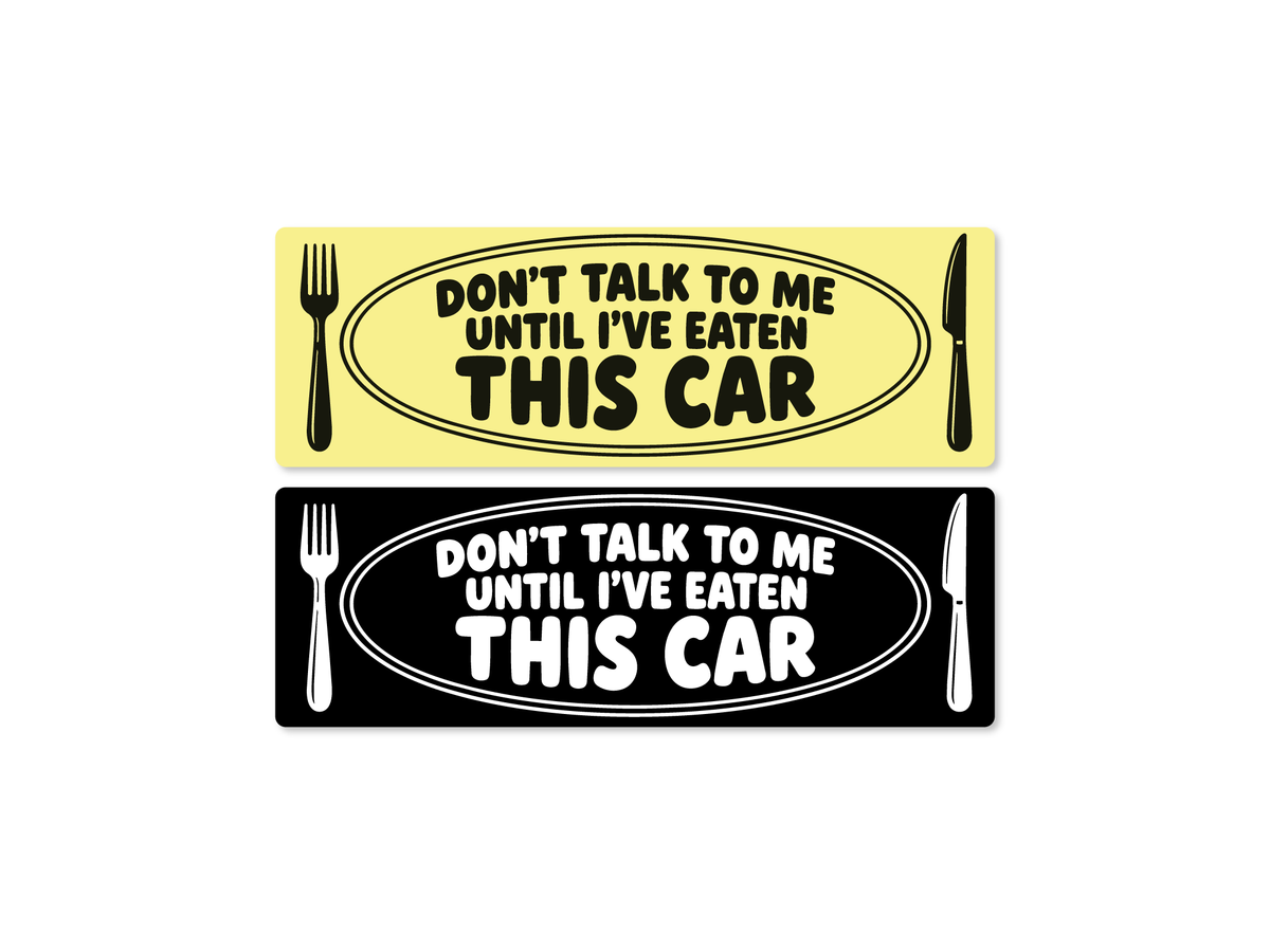 Two 9x3 bumper stickers reading “Don’t Talk to Me Until I’ve Eaten This Car,” shown in pale yellow with black text and black with white text, with fork and knife graphics.