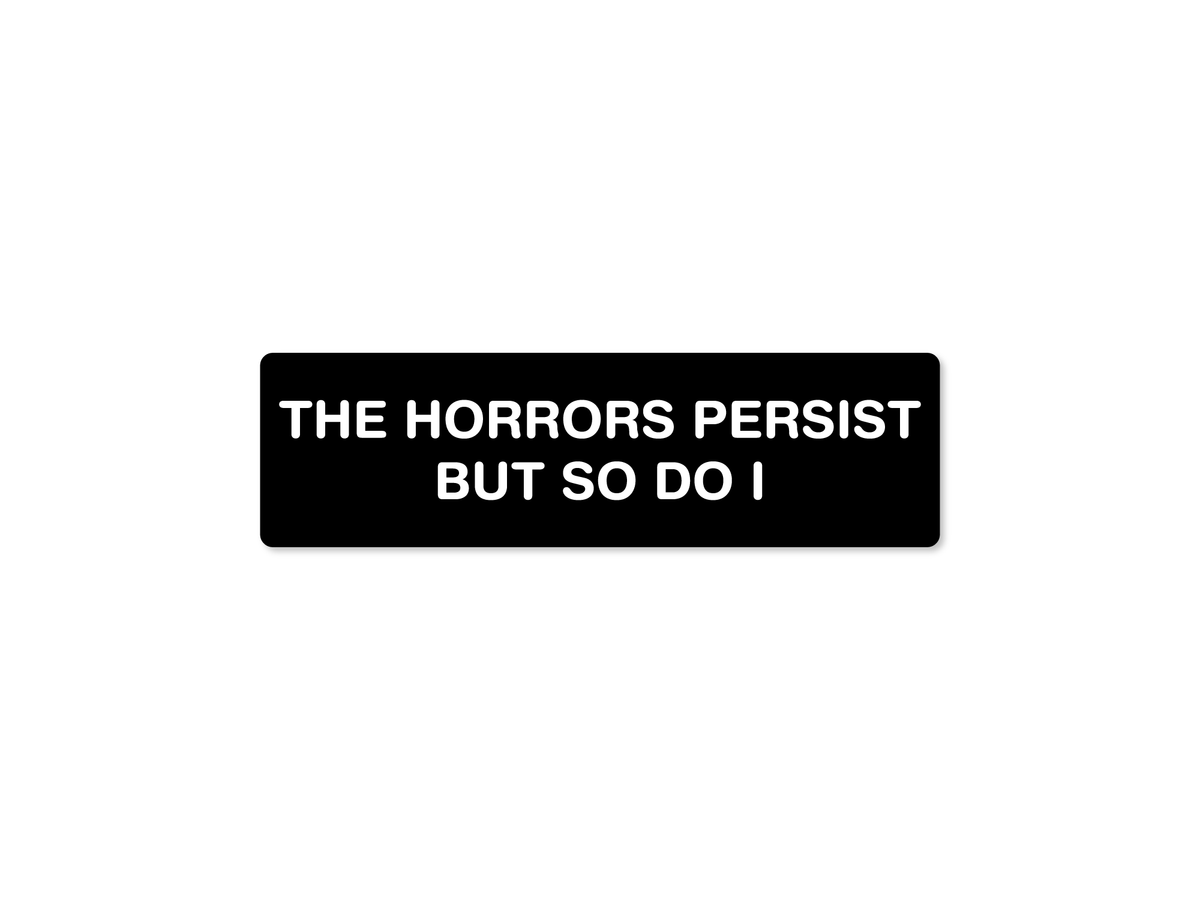 Black 7x2 bumper sticker with bold white text reading “The Horrors Persist But So Do I.”