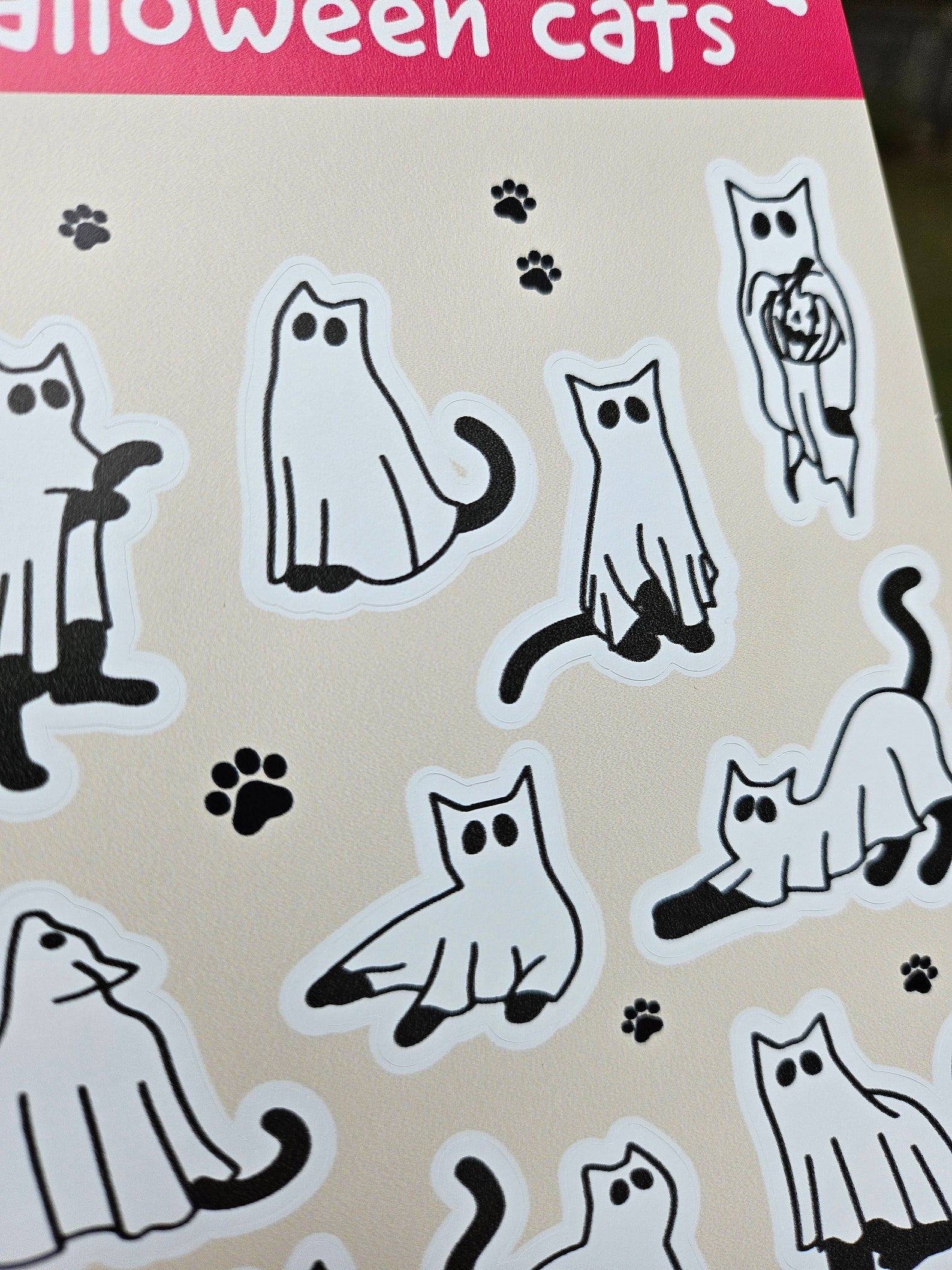 4x6 Halloween sticker sheet with 10 ghost cat vinyl stickers in different poses on a beige background with pink header and footer.