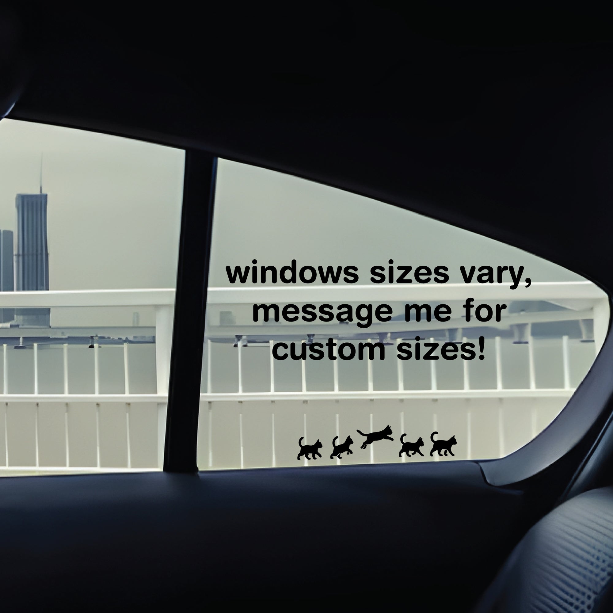 Car window with text and cat illustrations, showing a cityscape outside.