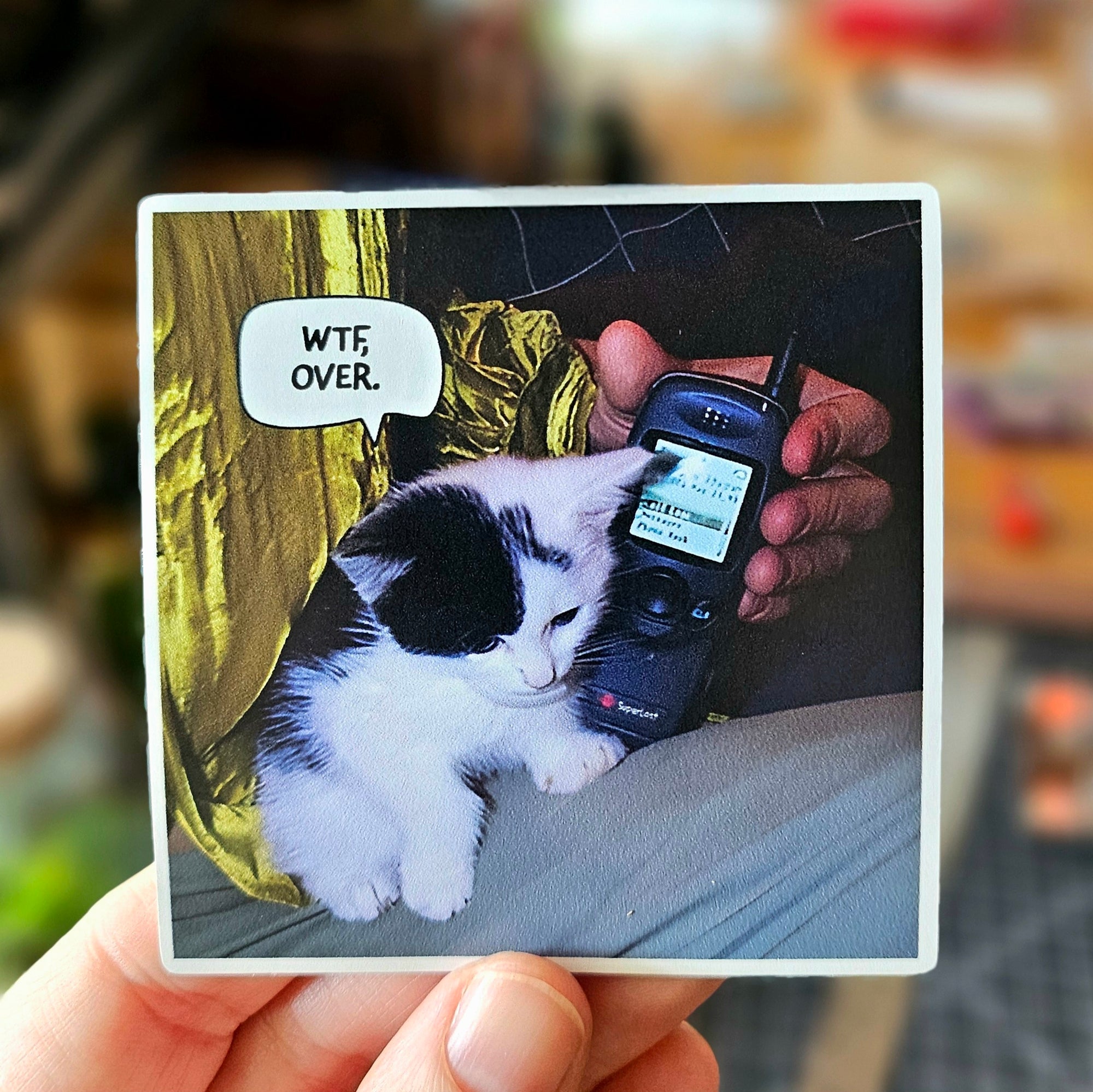 vinyl stickers featuring cats holding walkie talkies with speech bubbles that say “WTF, over.”
