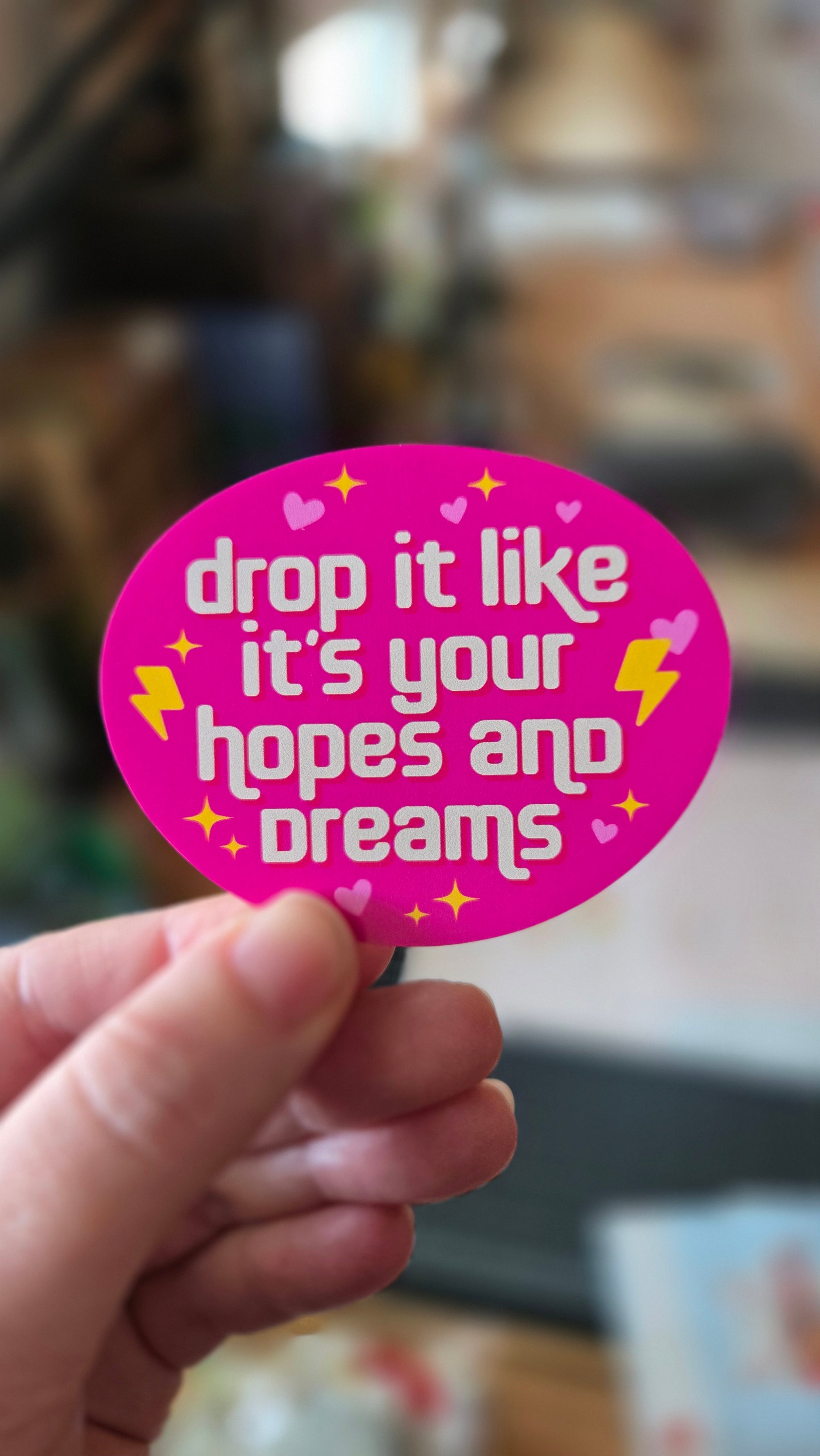round vinyl sticker options on pink with the phrase “drop it like it’s your hopes and dreams,” plus hearts, sparkles, and lightning bolts.
