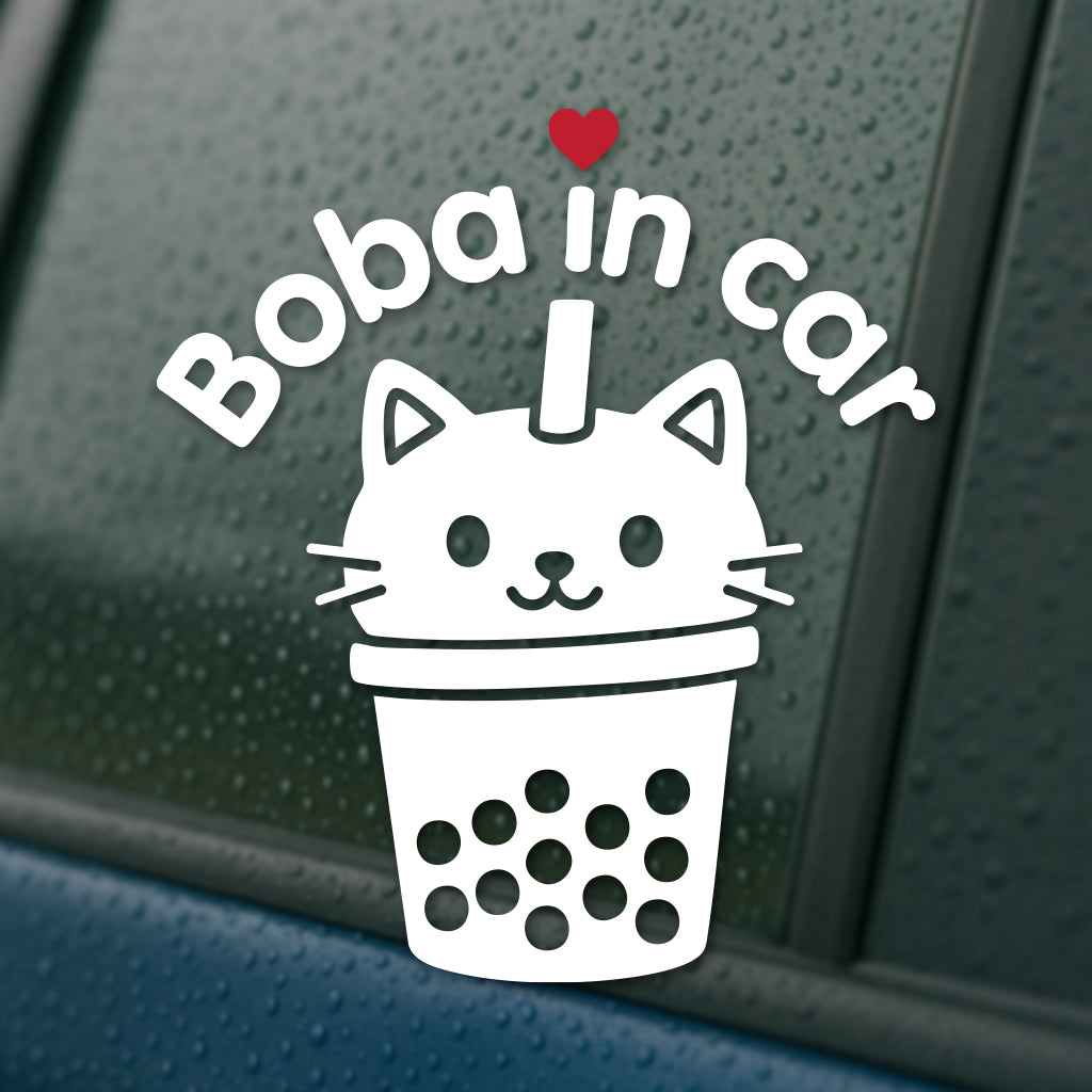 White vinyl decal on a rainy car window featuring a cat-shaped boba cup with a straw, red heart, and curved text that says “Boba in Cat.”
