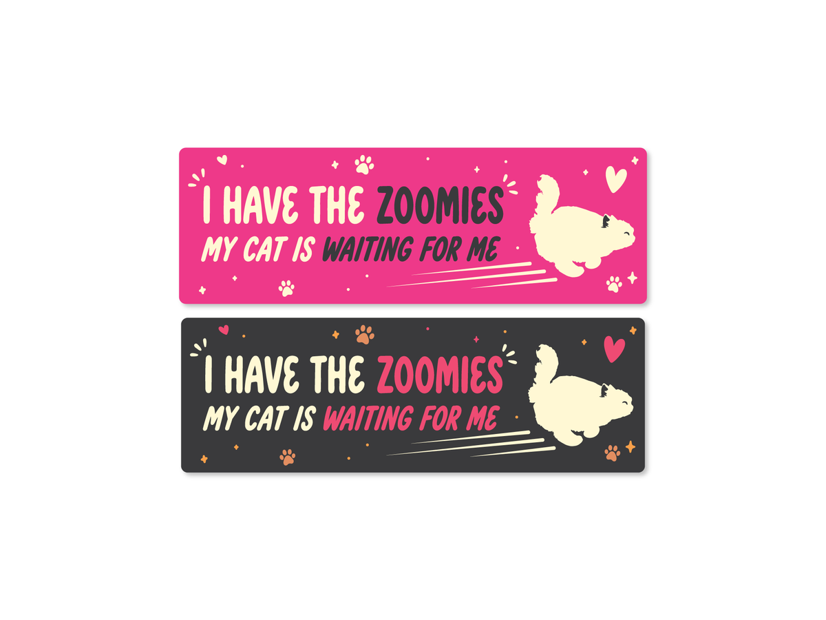 Two 9x3 bumper stickers with the phrase “I Have the Zoomies, My Cat Is Waiting For Me,” featuring a running cat silhouette, paw prints, hearts, and sparkles in pink and dark gray color options.